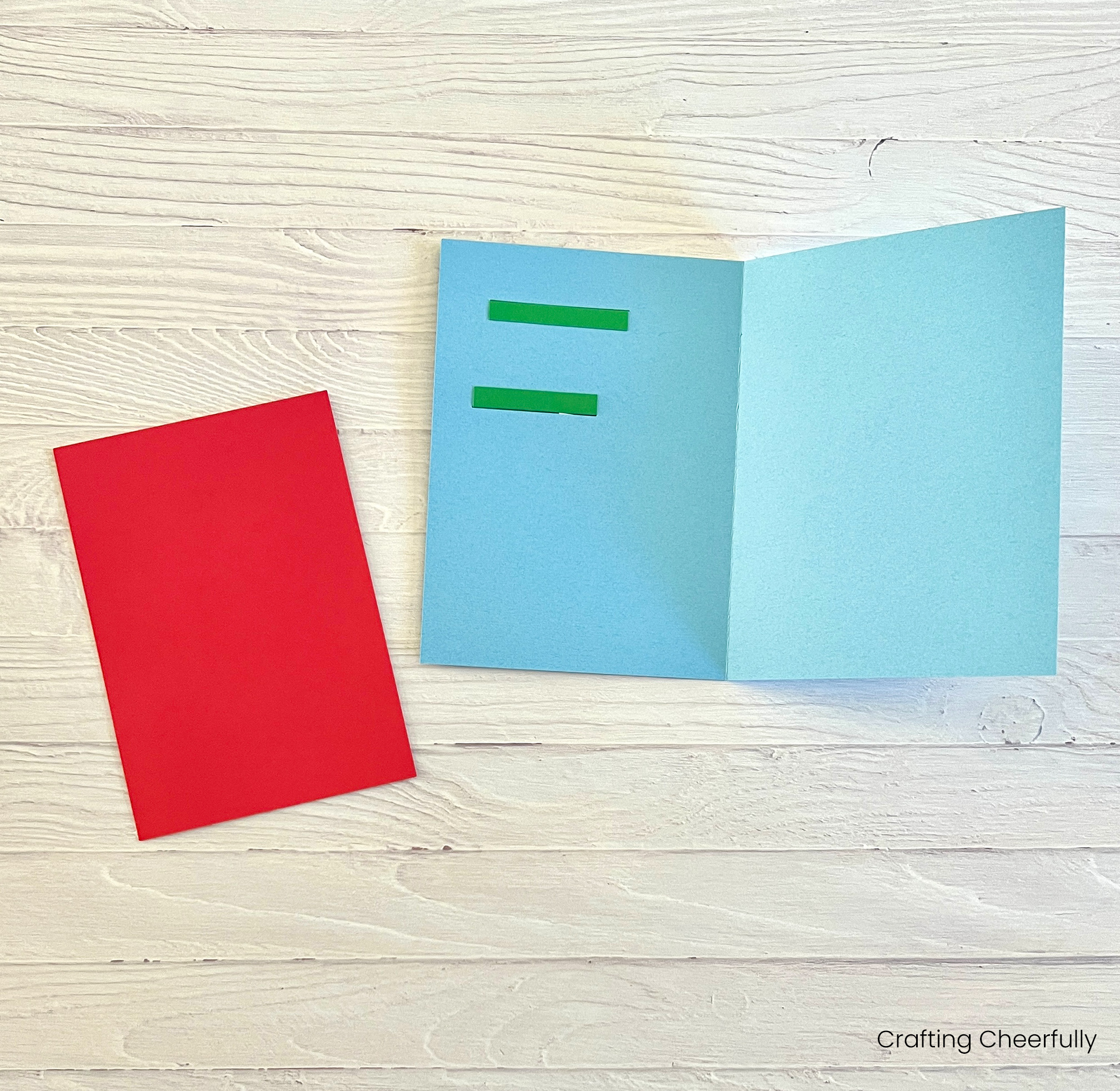 A red piece of cardstock lays next to the open card.