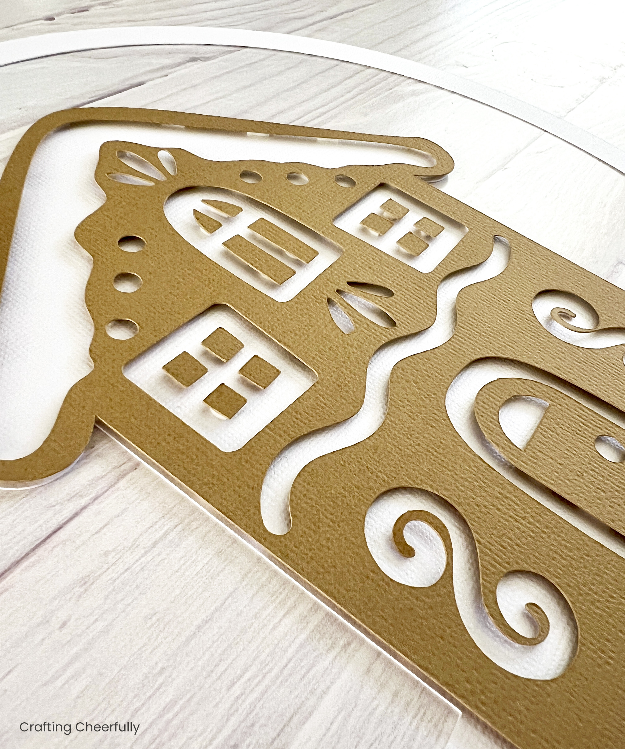 A side view of the paper gingerbread house added to the white snow layer of cardstock.