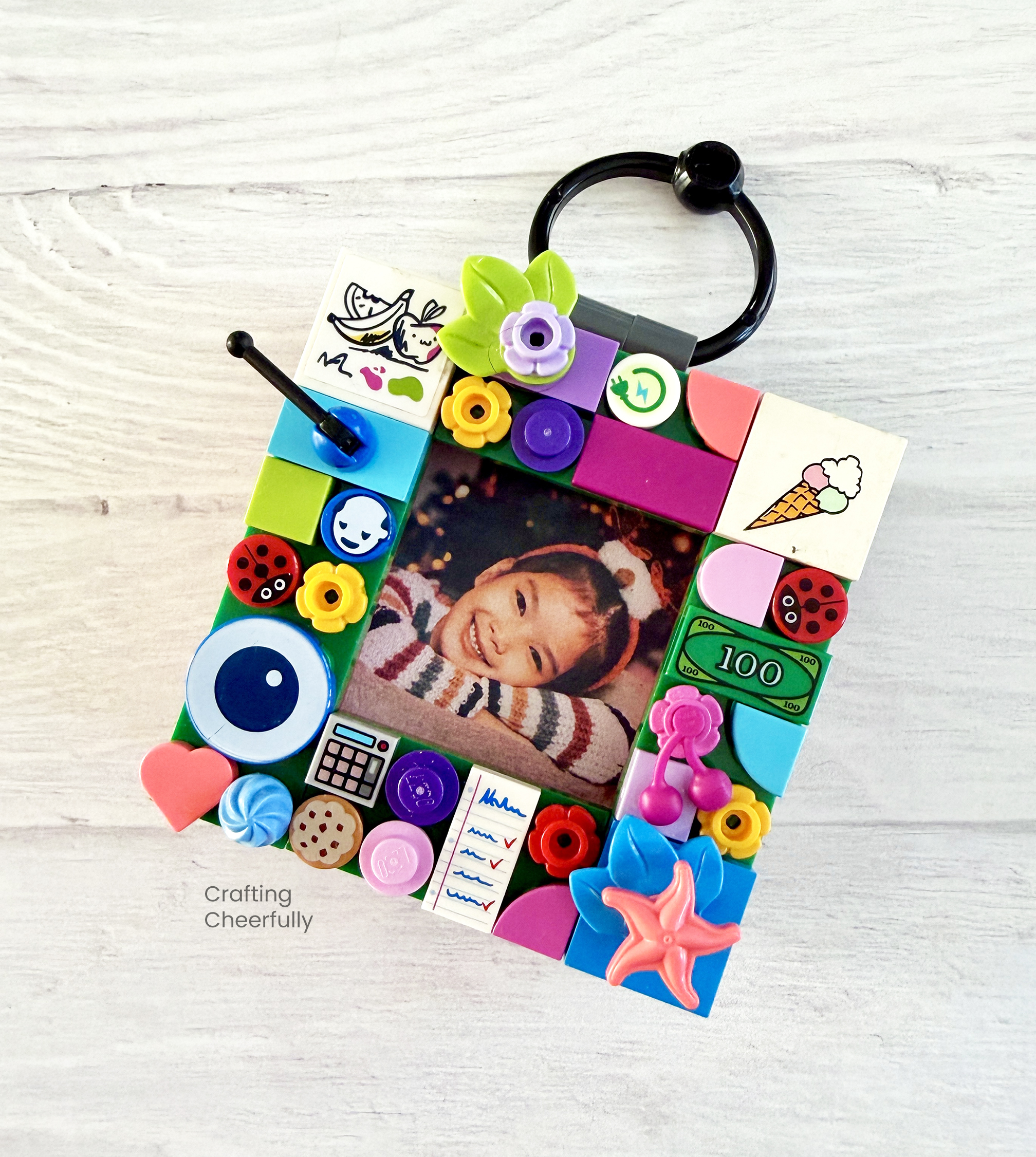 A lego ornament frame is decorated with fun Lego pieces and printed plates.