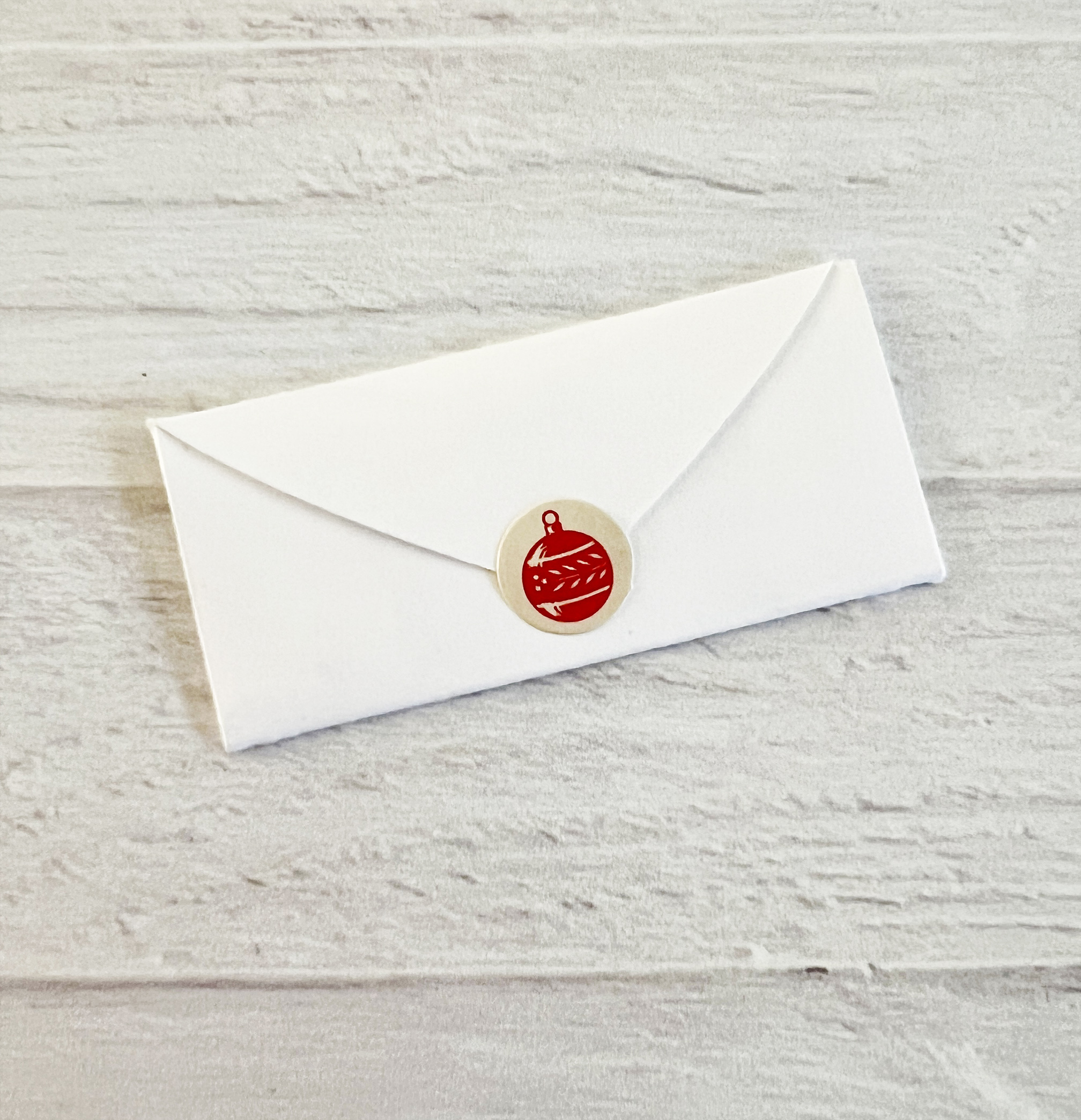 A cute Christmas-themed sticker is placed on the mini envelope flat to keep it closed.