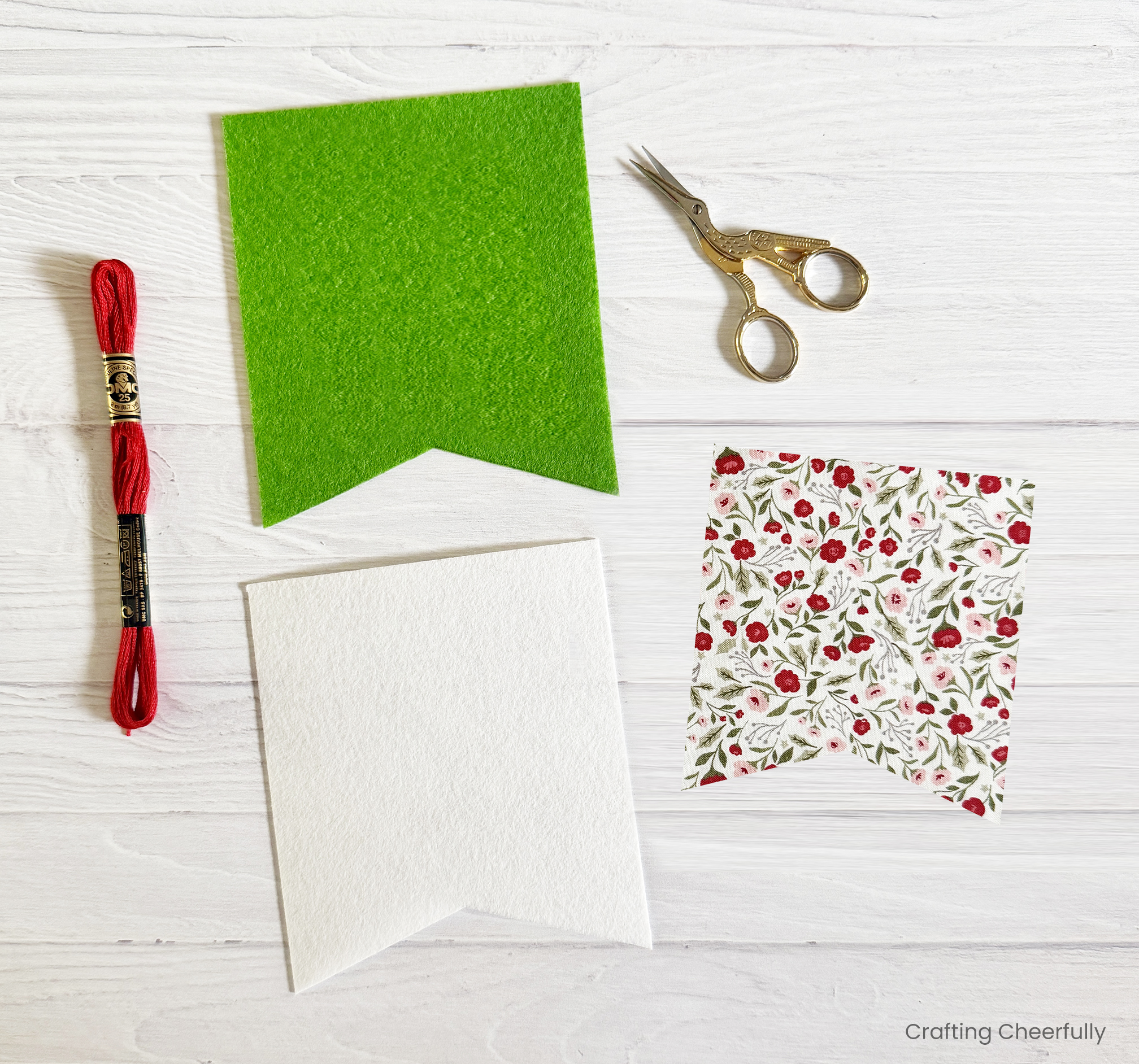 Green and white felt pennants, a piece of fabric charm pack piece, embroidery floss and a small embroidery scissors.