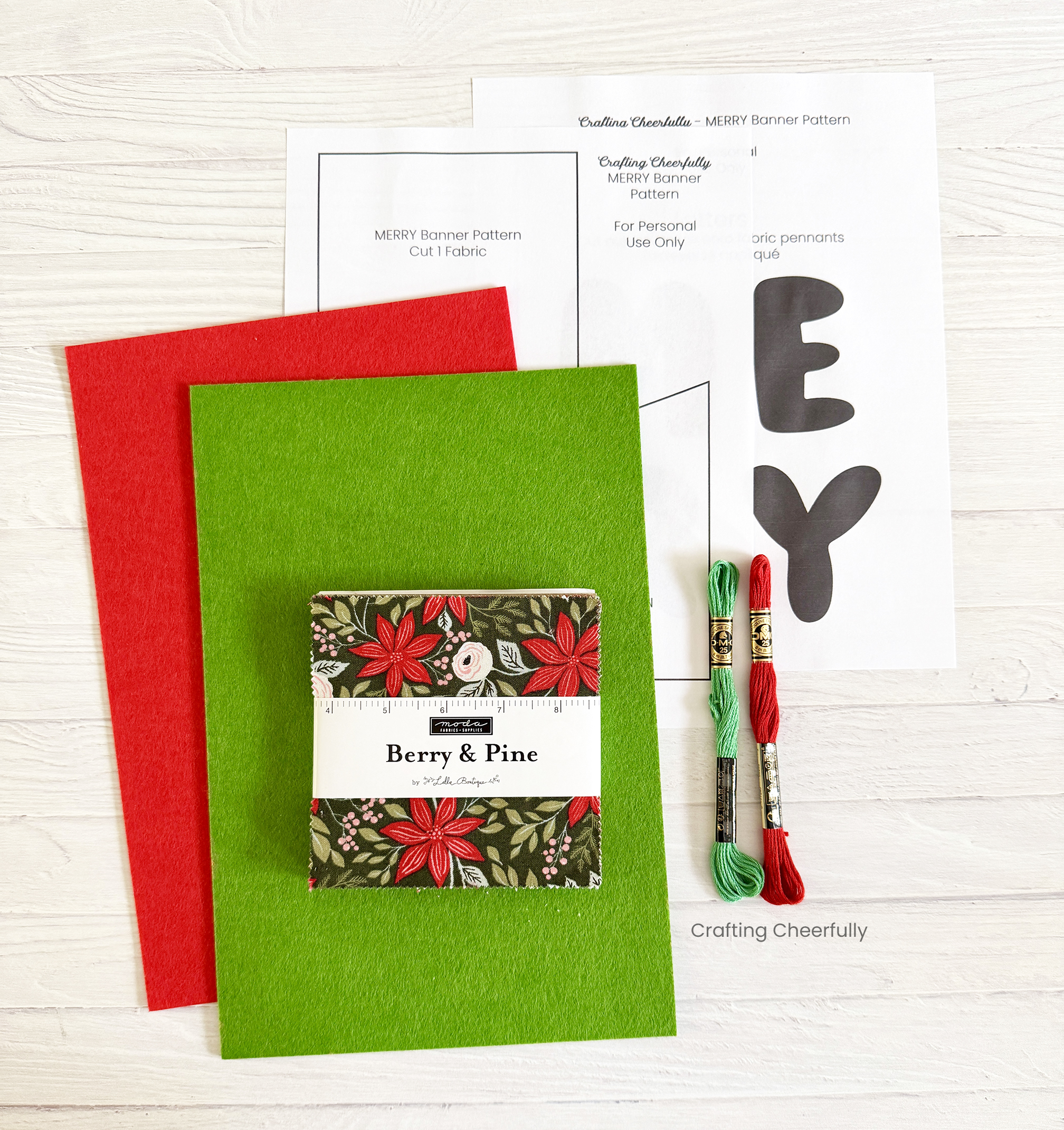Supplies including red and green felt, a holiday charm pack, embroidery floss and pattern.