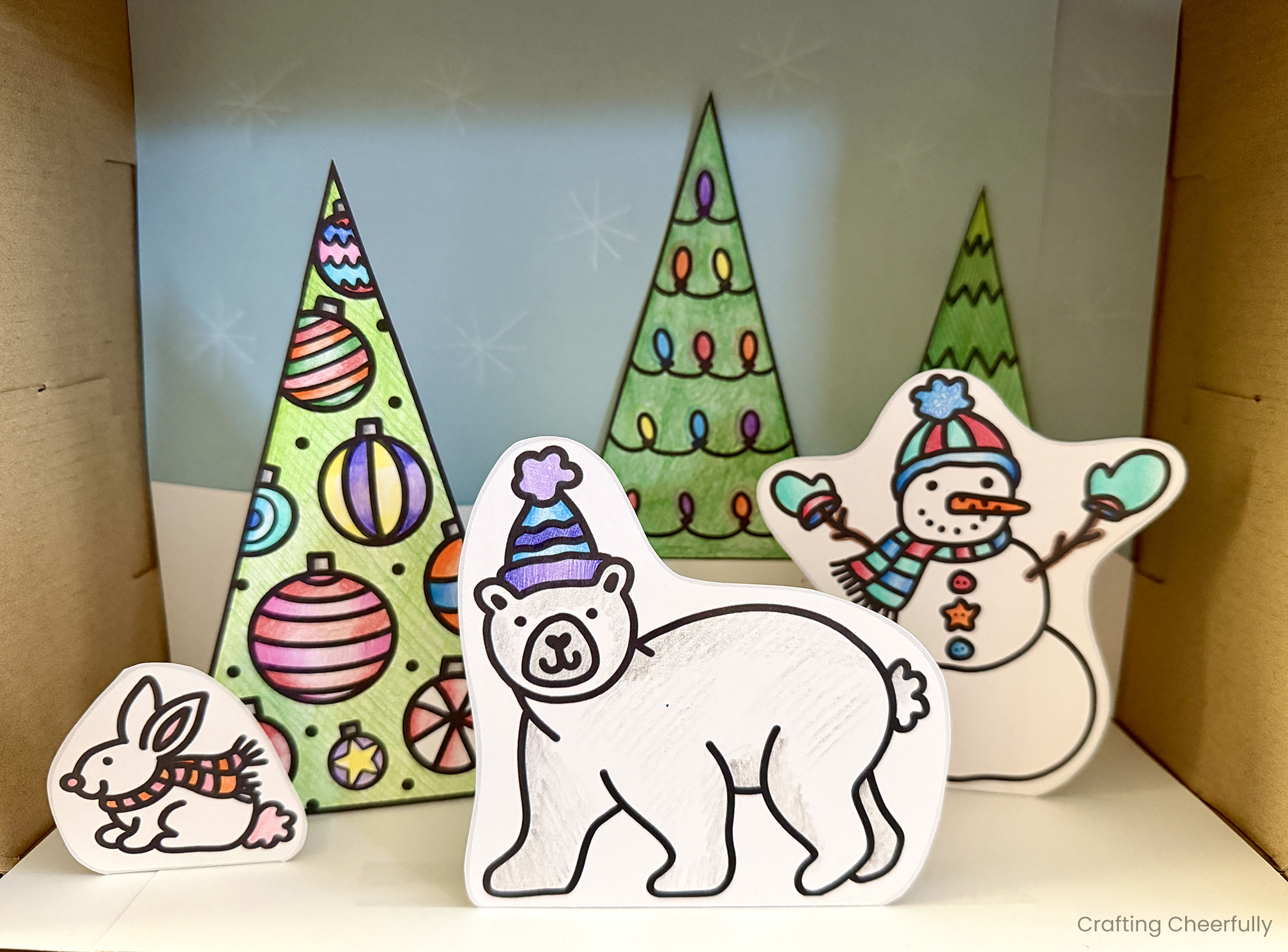 A shadow box with a winter and Christmas scene inside.