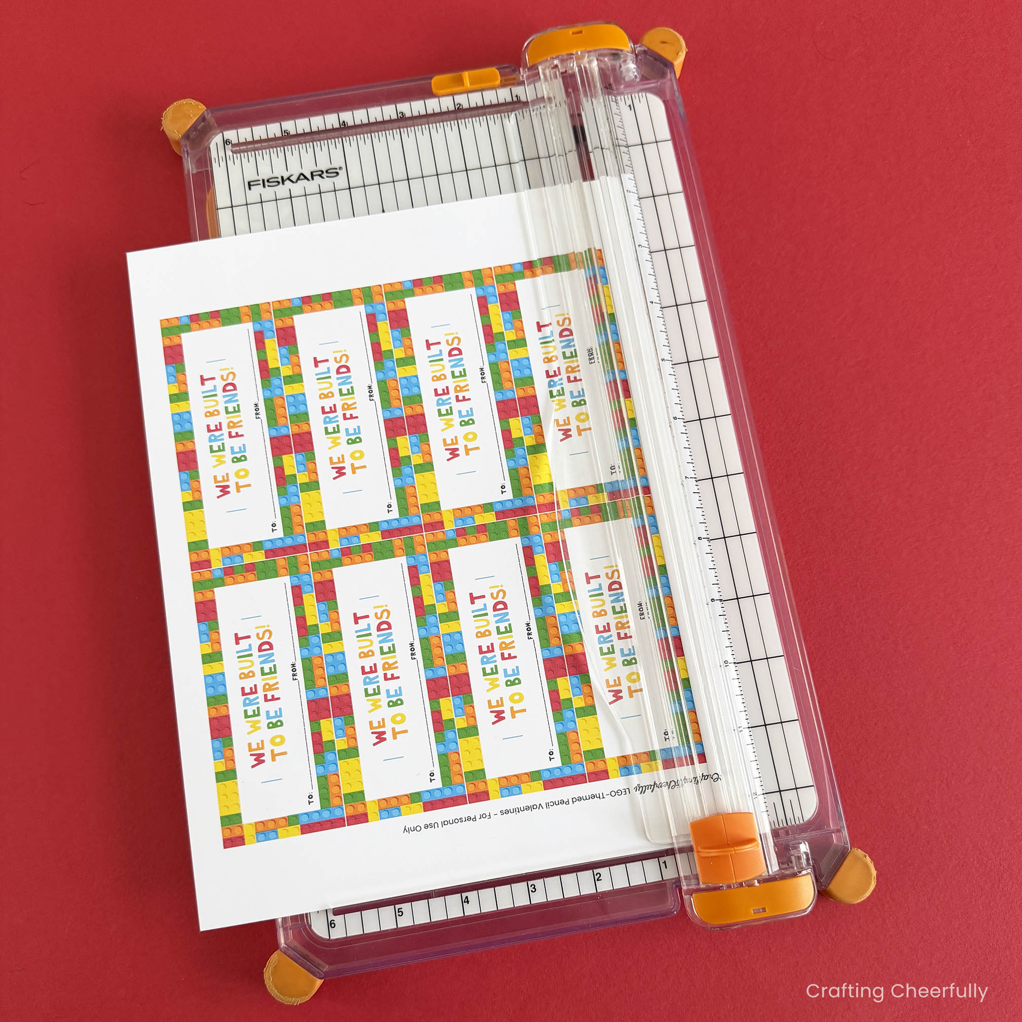 Lego Valentine printables being cut out with a paper trimmer.