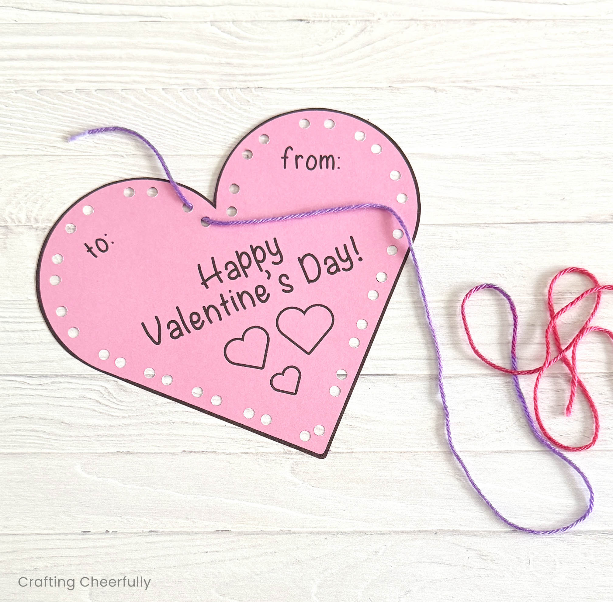 A piece of yarn is pulled through the first hole at the top left.