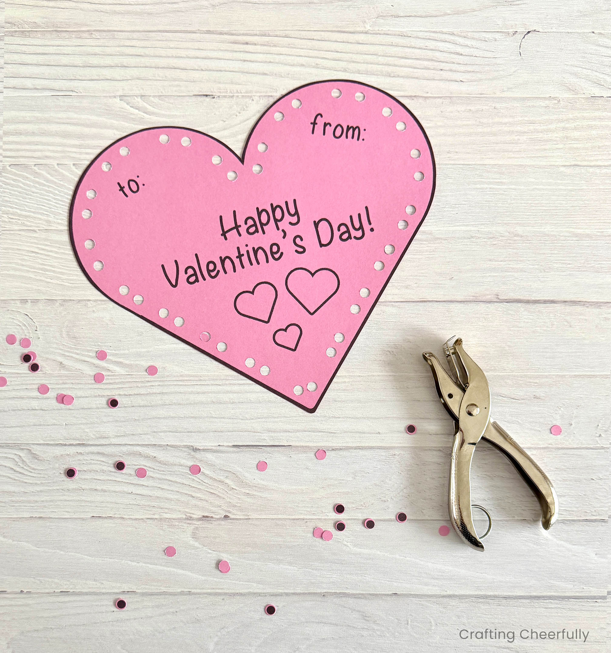 The paper heart valentine with all of the holes around the edge punched.