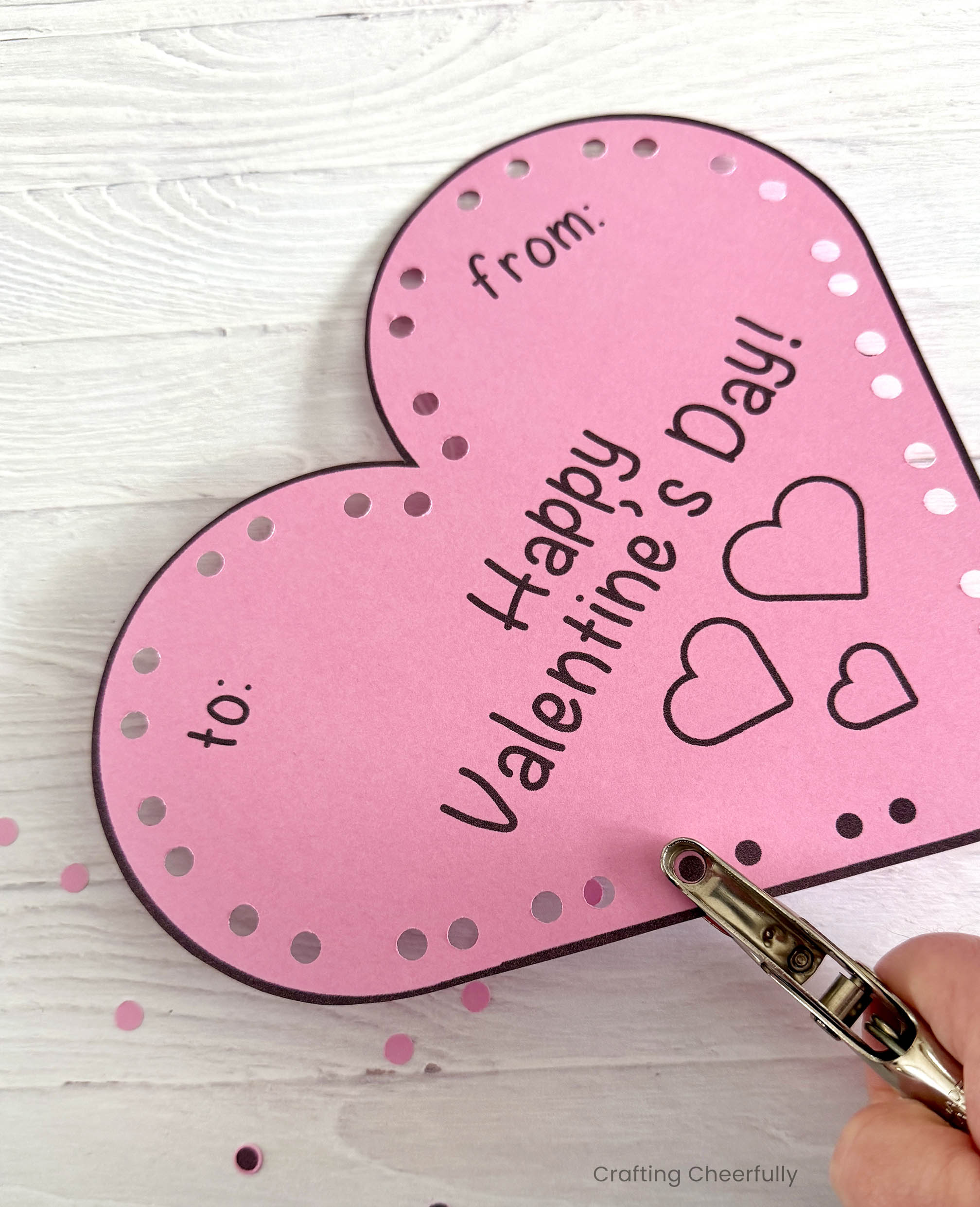 A hole punch is used to punch holes following the printed guide around the edges.