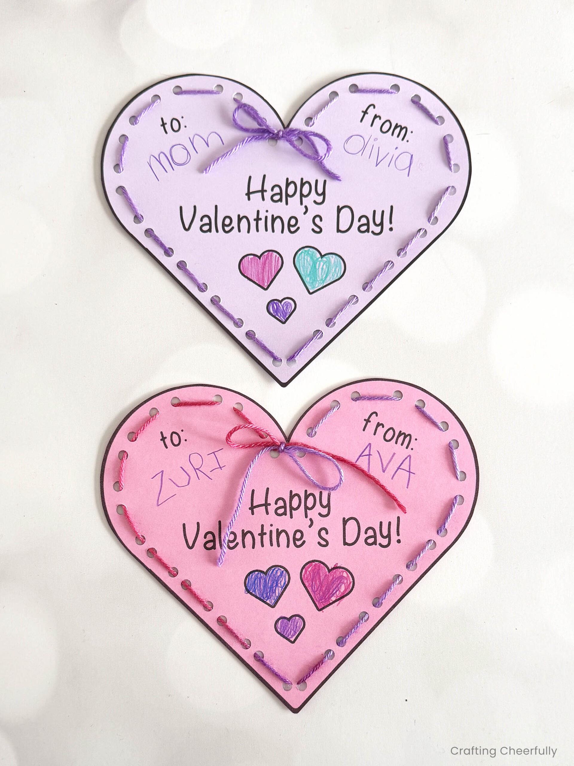Two lacing heart valentines colored in and laced with yarn.