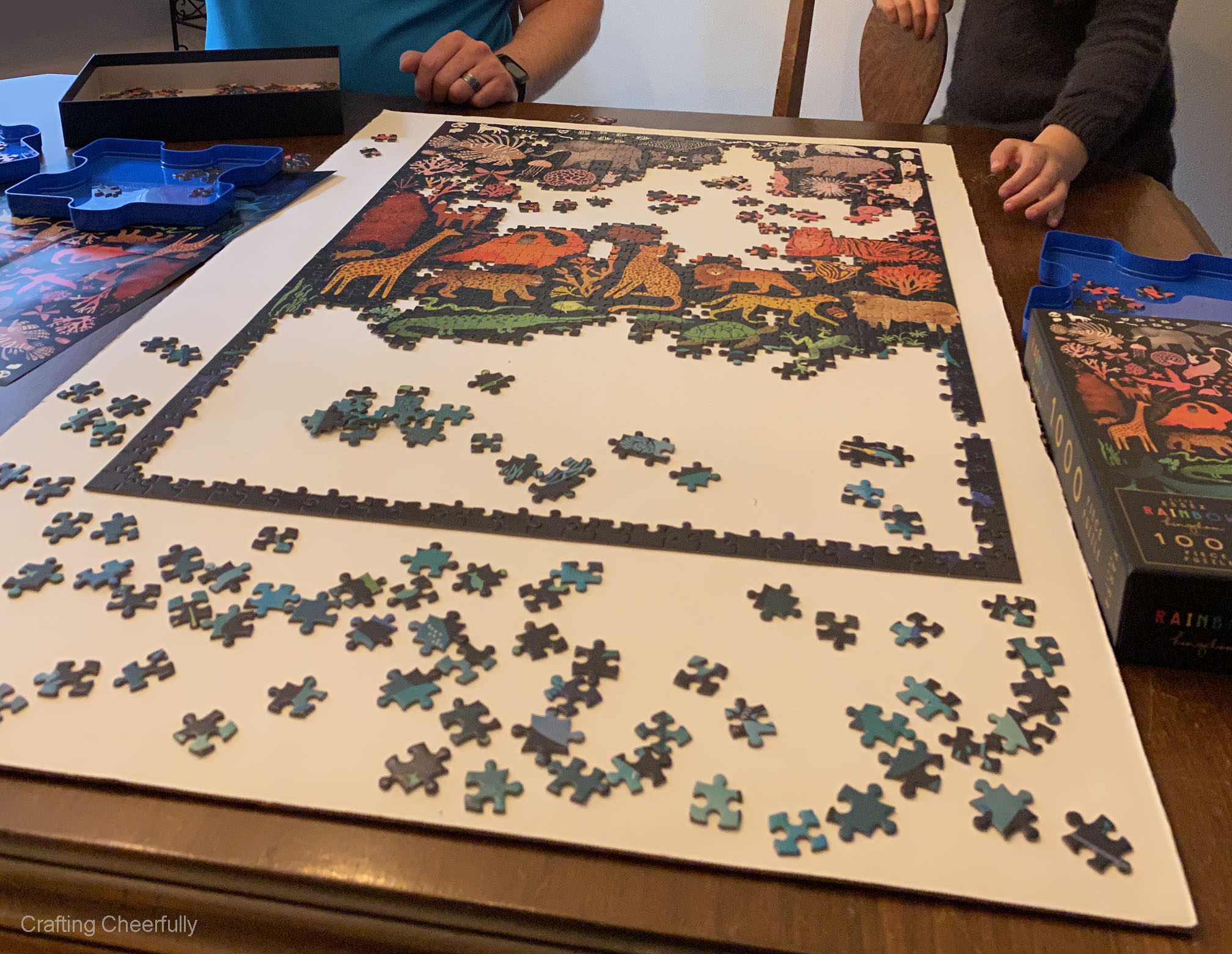 Family putting together jigsaw puzzle on table.