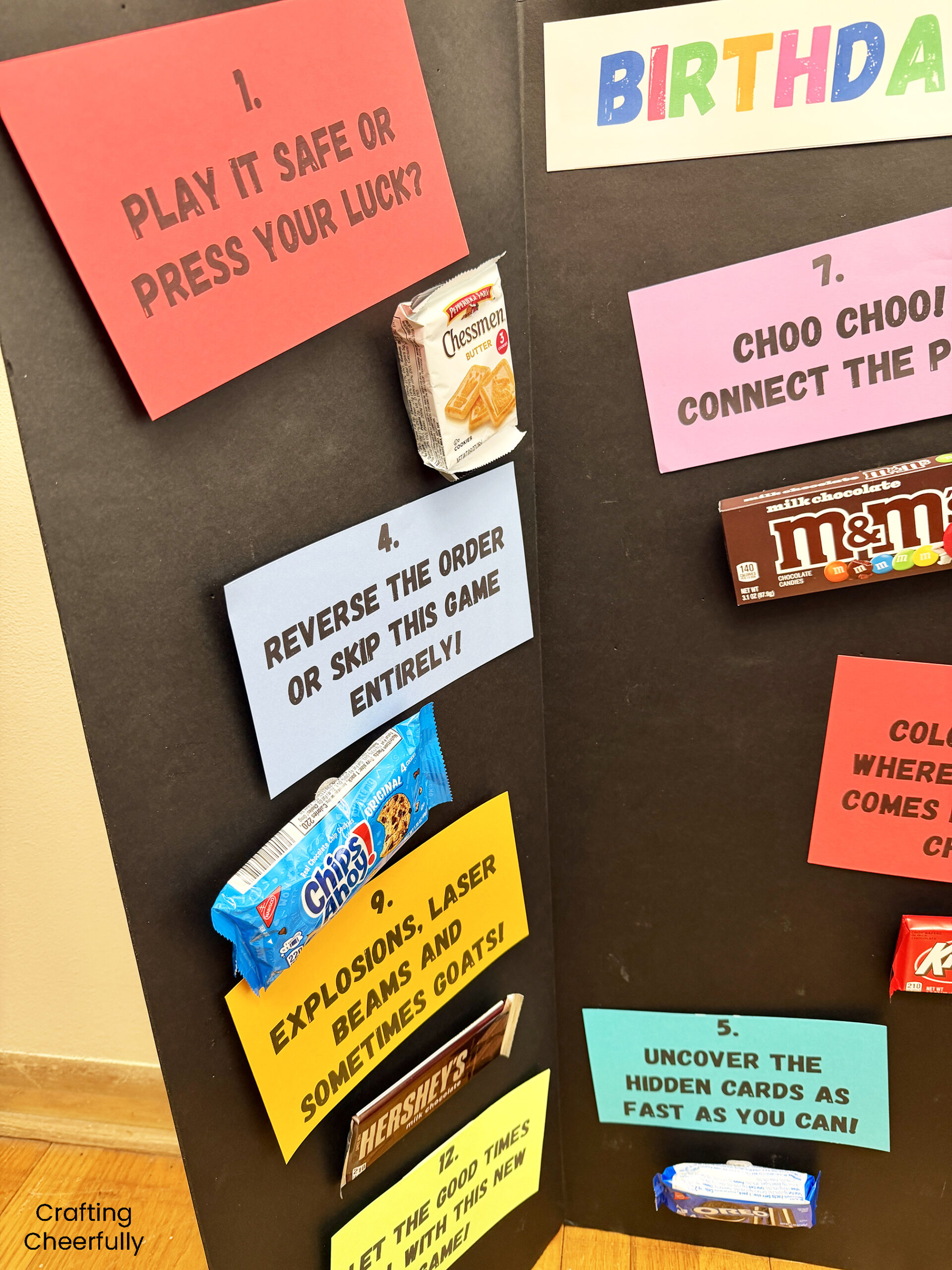 Clue cards and candy are attached to a black trifold board.