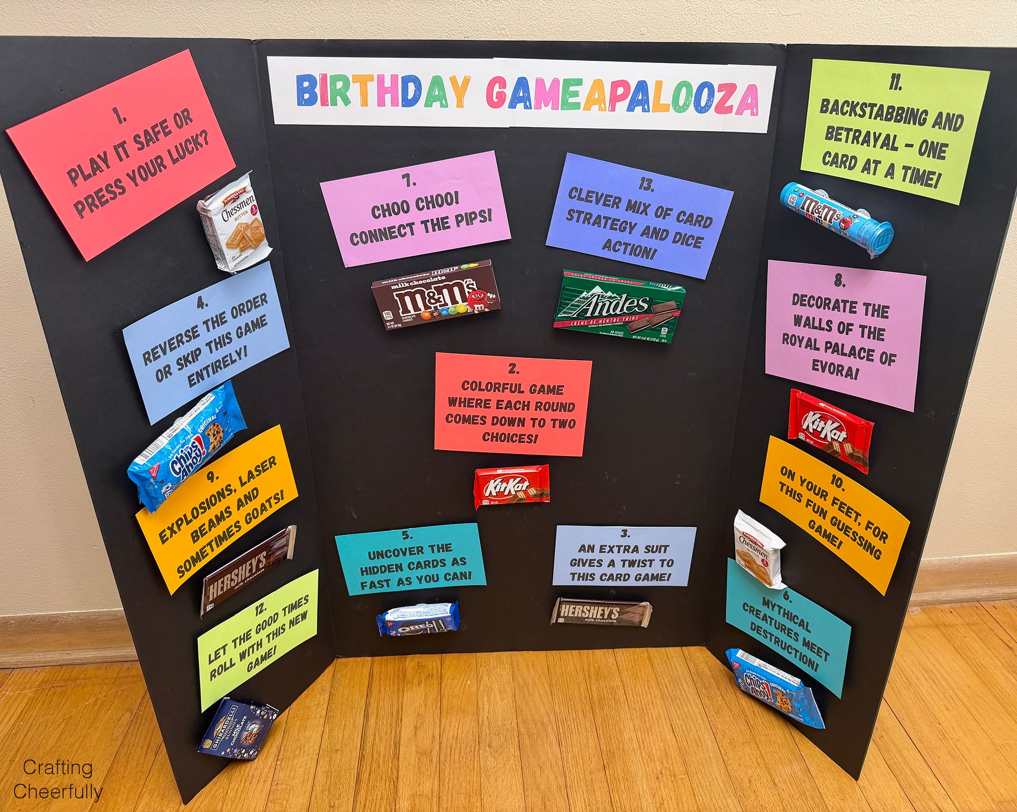 Trifold board with colorful pieces of paper describing games and candy next to it.