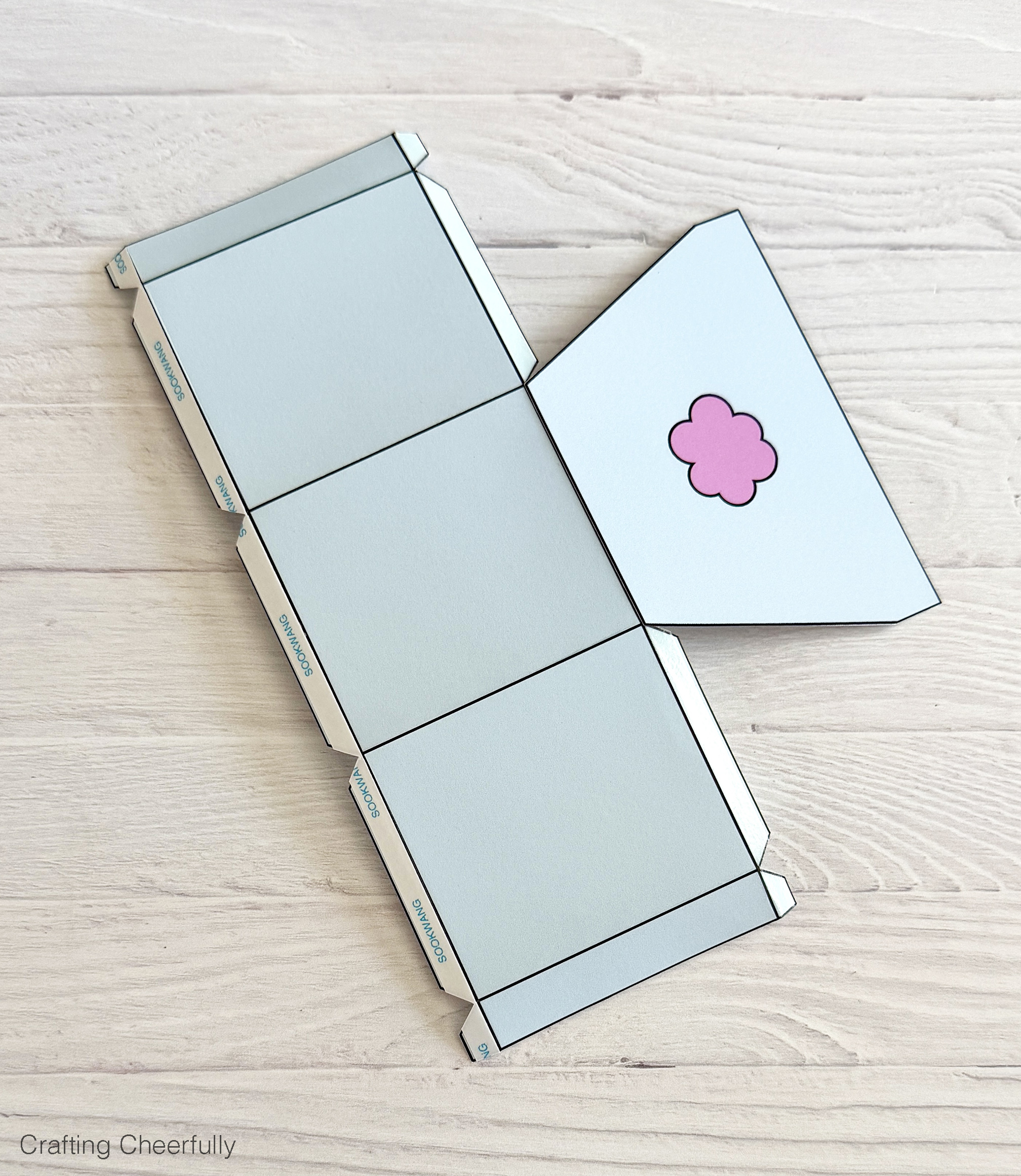 The back of the treat box is attached to a tab on the large scored piece of paper.