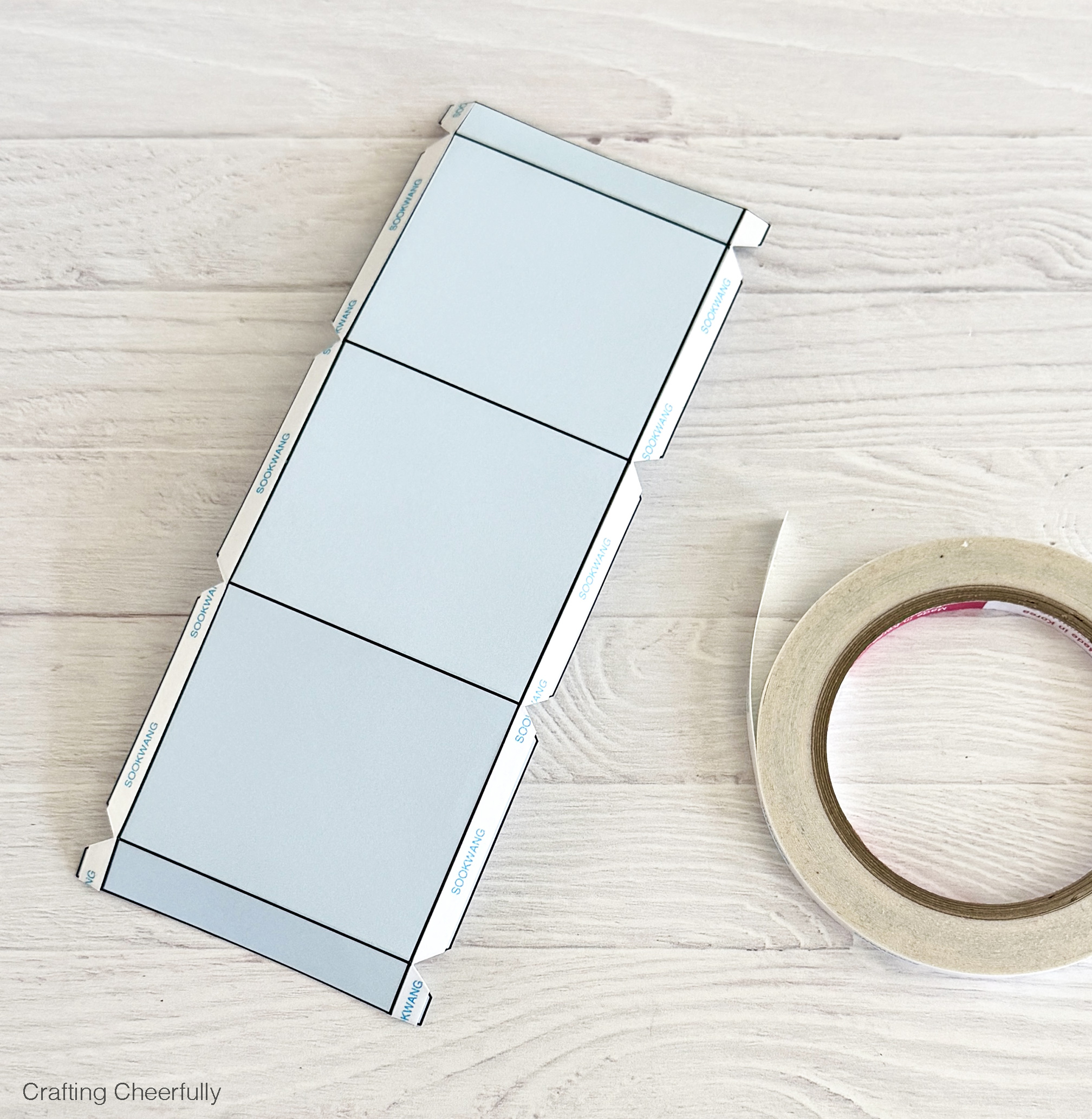 Double sided tape adhesive is applied to the tabs of the treat box.