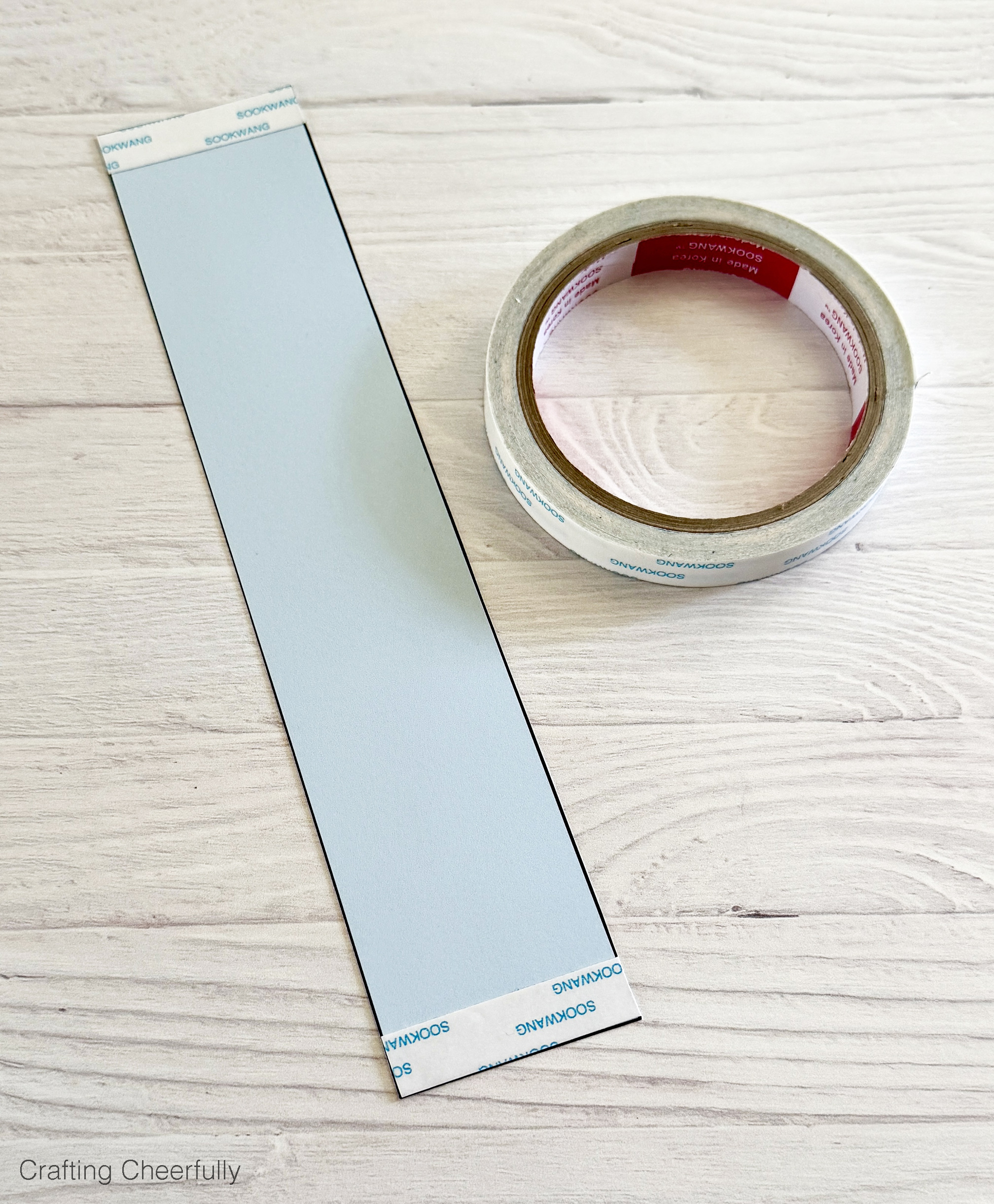 Double sided tape is attached to the ends of the paper handle.