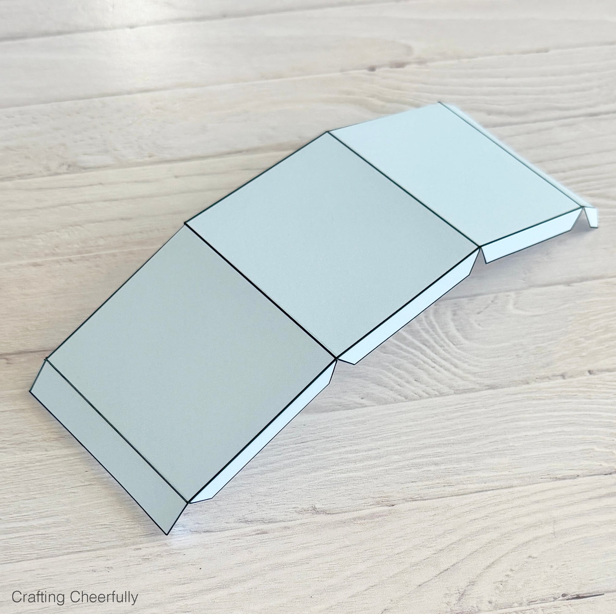 The scored piece of paper is gently folded along the score lines.