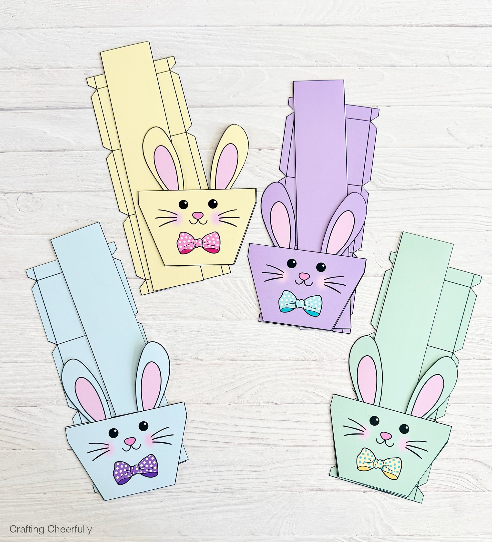 Pieces for four bunny boxes are cut and grouped together on a table.