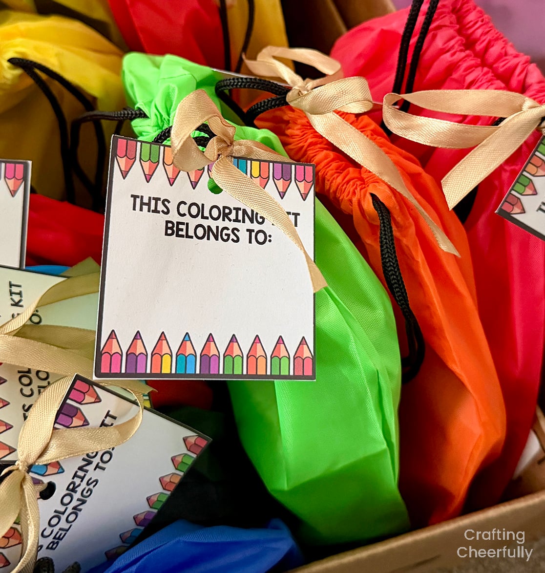 A tag that reads "This coloring kit belongs to" is attached to each cinch sack coloring kit.