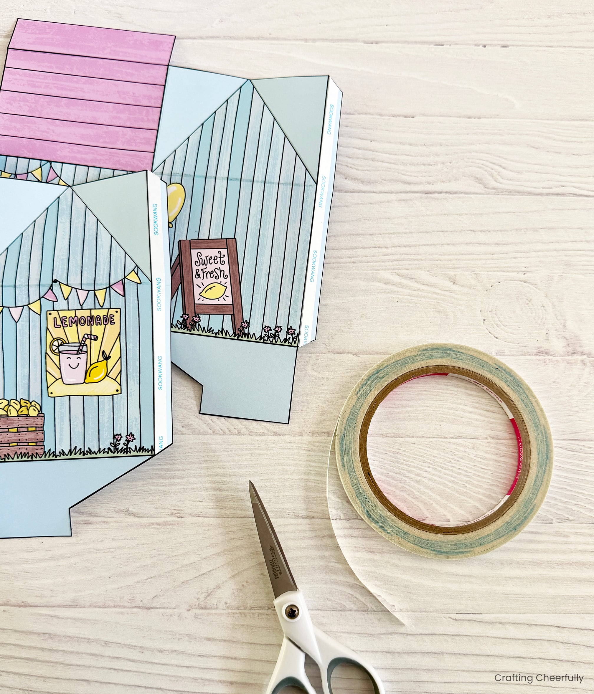 Double-sided tape is applied to the tabs on the treat box printables.