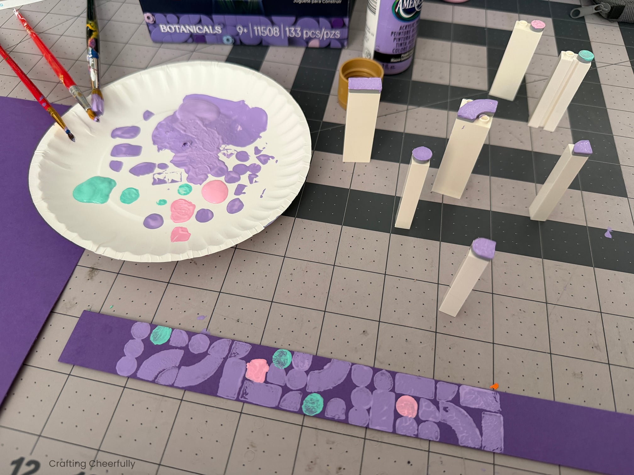 LEGO stamps mark a thin piece of purple paper creating a geometric pattern.