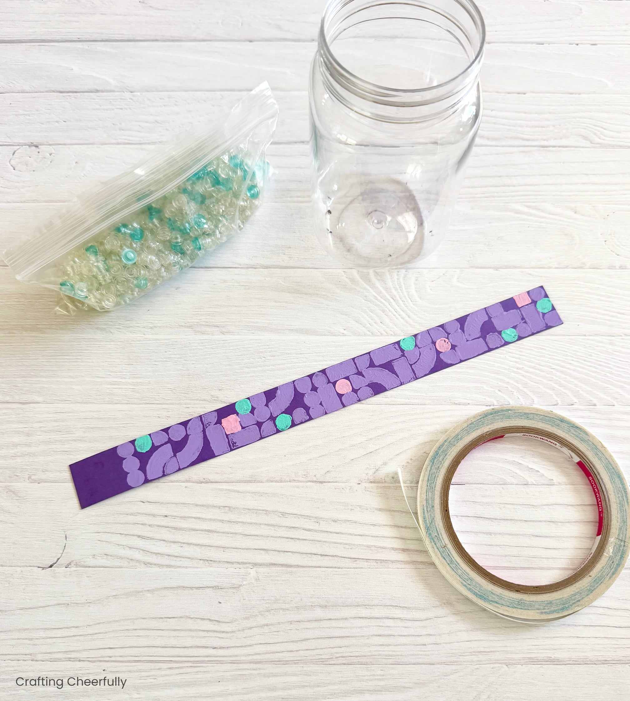 Double-sided tape lays next to the stamped strip of paper and mason jar.