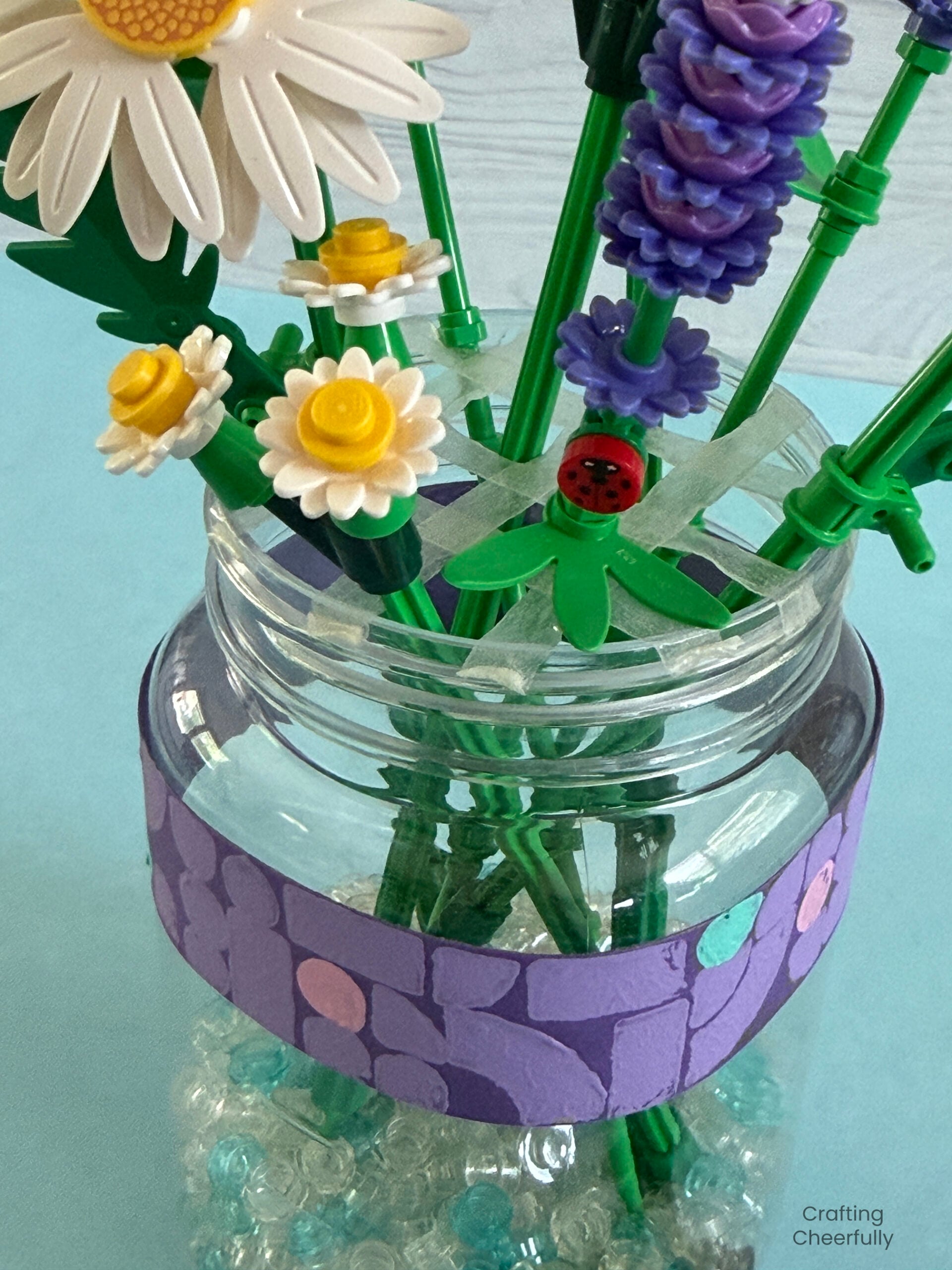 LEGO flower stems are placed in the vase through the little holes in the double-sided tape.