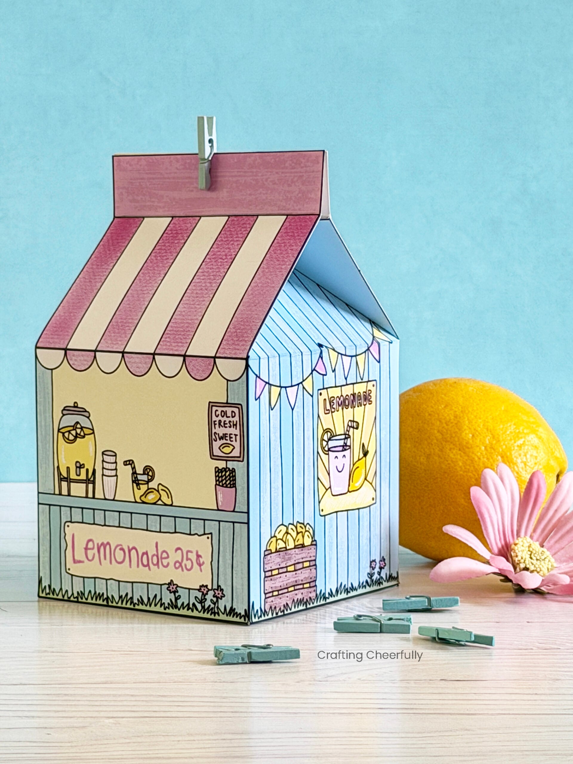 Lemonade Stand treat box sits next to a lemon.