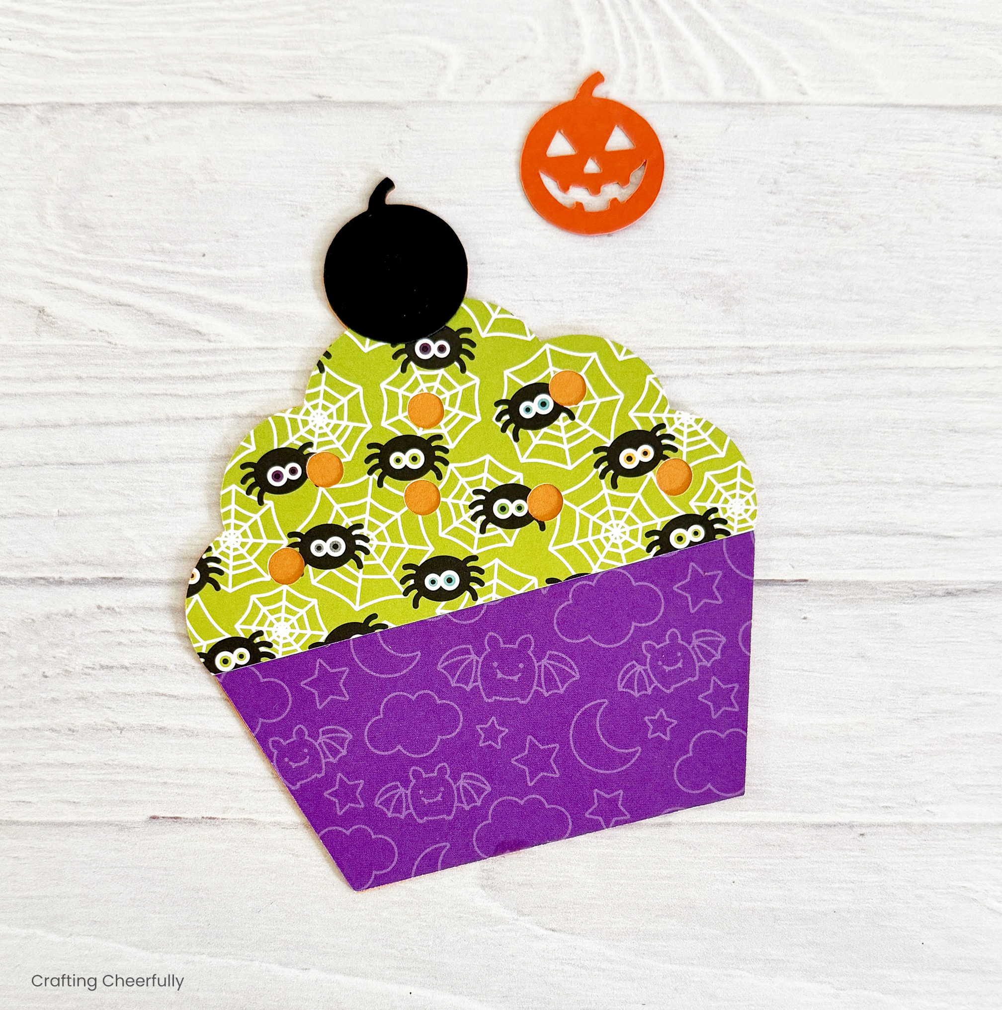 The black pumpkin piece is glued to the top of the cupcake.