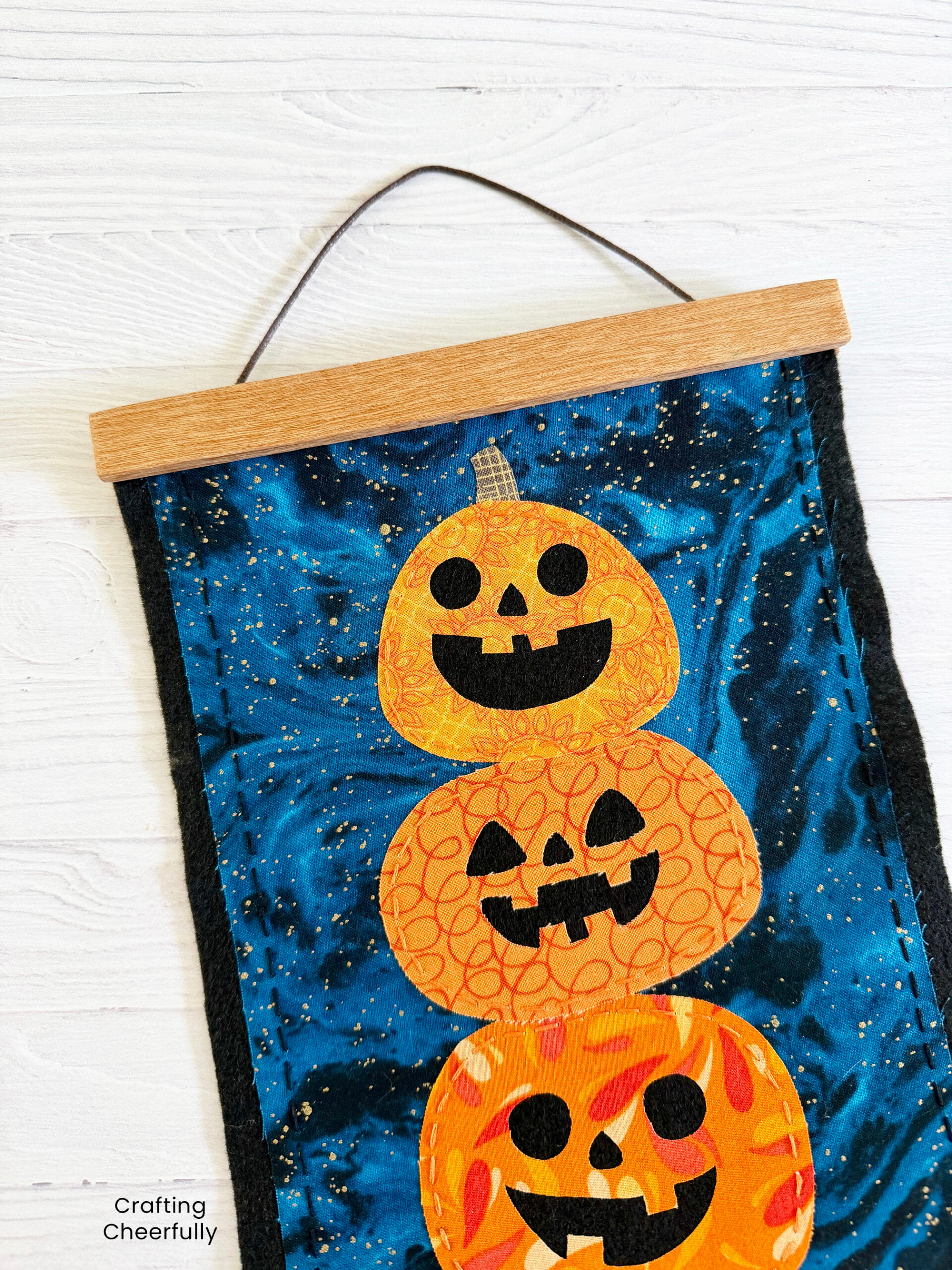 Halloween wall hanging with silly pumpkins stacked in a tower.